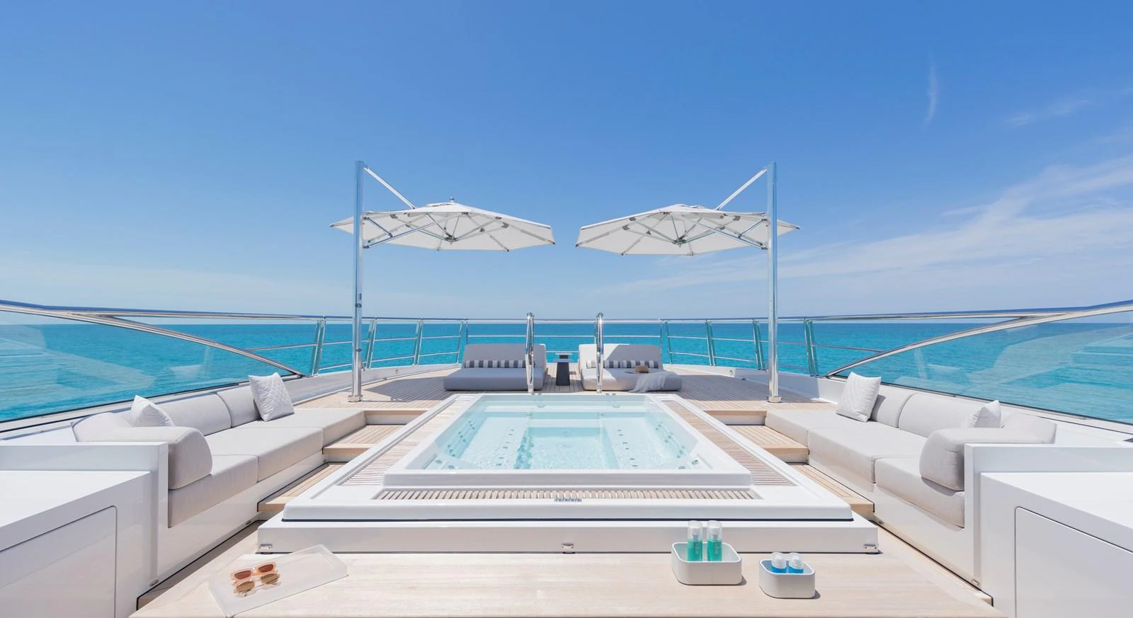 The sundeck features a luxurious jacuzzi surrounded by comfortable seating and shaded by elegant umbrellas. aboard ENTOURAGE Yacht for Sale