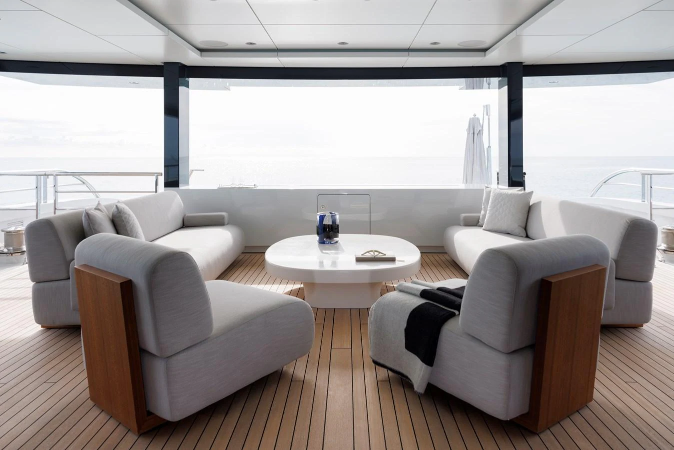 The aft deck features a stylish and comfortable seating area with modern furnishings and a serene ocean view. aboard ENTOURAGE Yacht for Sale