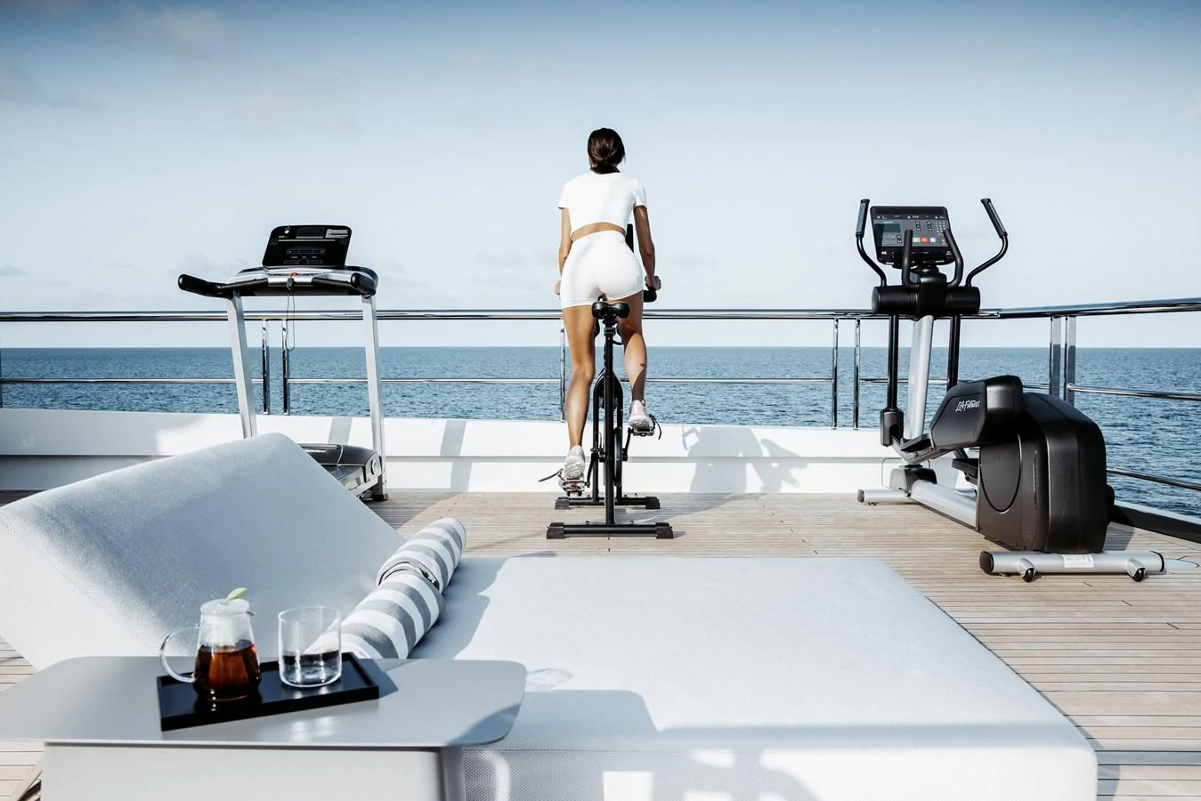The yacht features a well-equipped fitness area with stunning ocean views. aboard ENTOURAGE Yacht for Sale