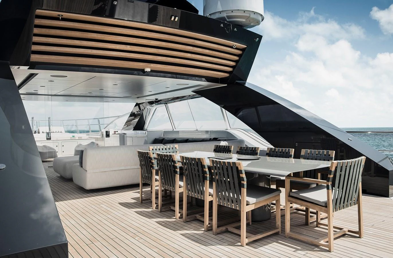 The aft deck features a spacious dining area with modern seating and a sleek design, perfect for alfresco meals. aboard ENTOURAGE Yacht for Sale
