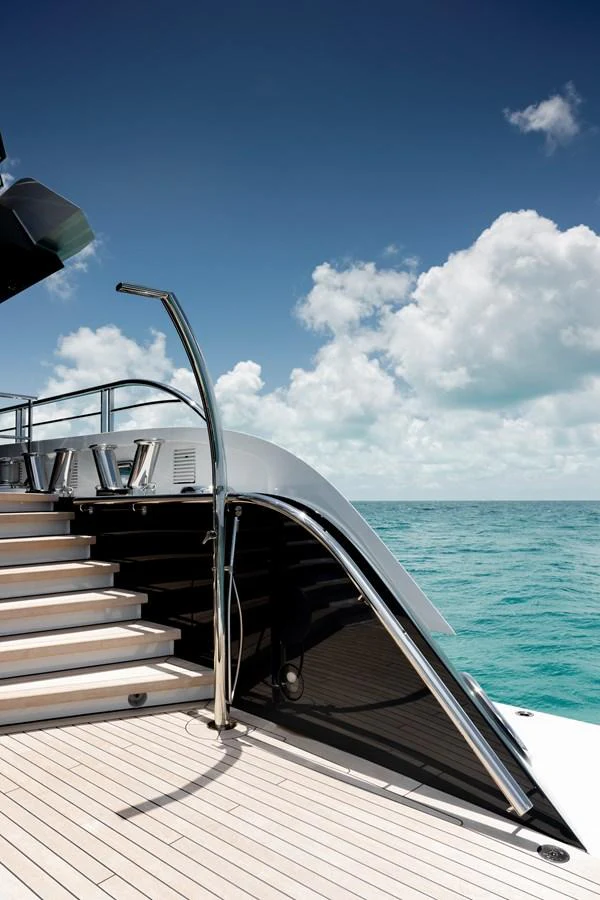 The aft deck features sleek stairs leading up to an inviting upper level with stunning ocean views. aboard ENTOURAGE Yacht for Sale