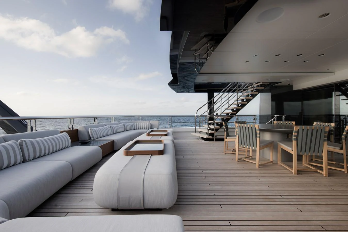 The aft deck features luxurious seating and dining areas with stunning ocean views. aboard ENTOURAGE Yacht for Sale