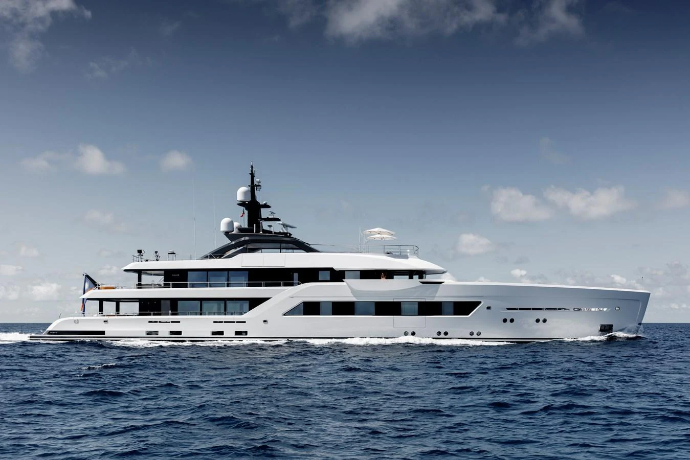 A sleek and modern yacht cruising on open waters under a clear sky. aboard ENTOURAGE Yacht for Sale
