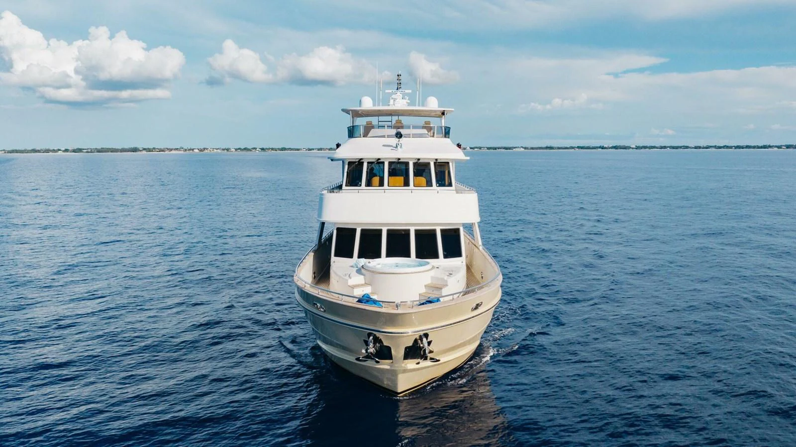 A luxurious yacht cruises on calm waters under a clear blue sky. aboard AURELIA Yacht for Sale