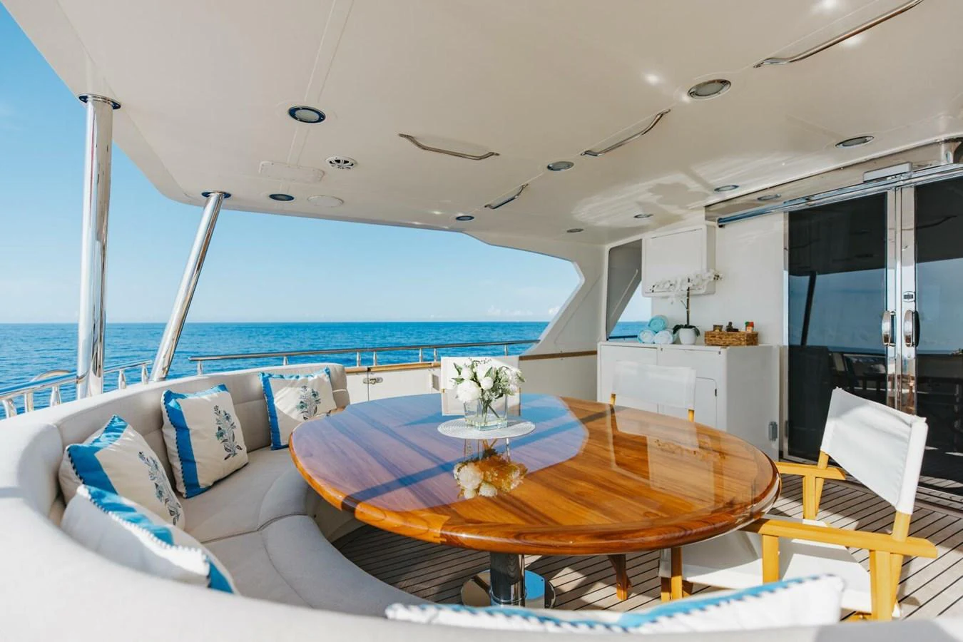 The aft deck features a spacious dining area with a polished wooden table and comfortable seating, perfect for al fresco meals with a view of the sea. aboard AURELIA Yacht for Sale