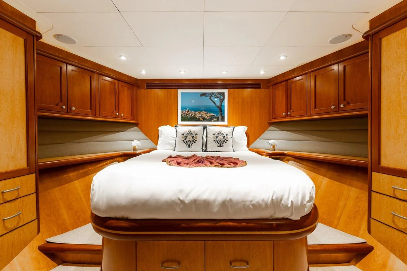 The stateroom features a luxurious bed with ample storage and elegant wood finishes. aboard AURELIA Yacht for Sale