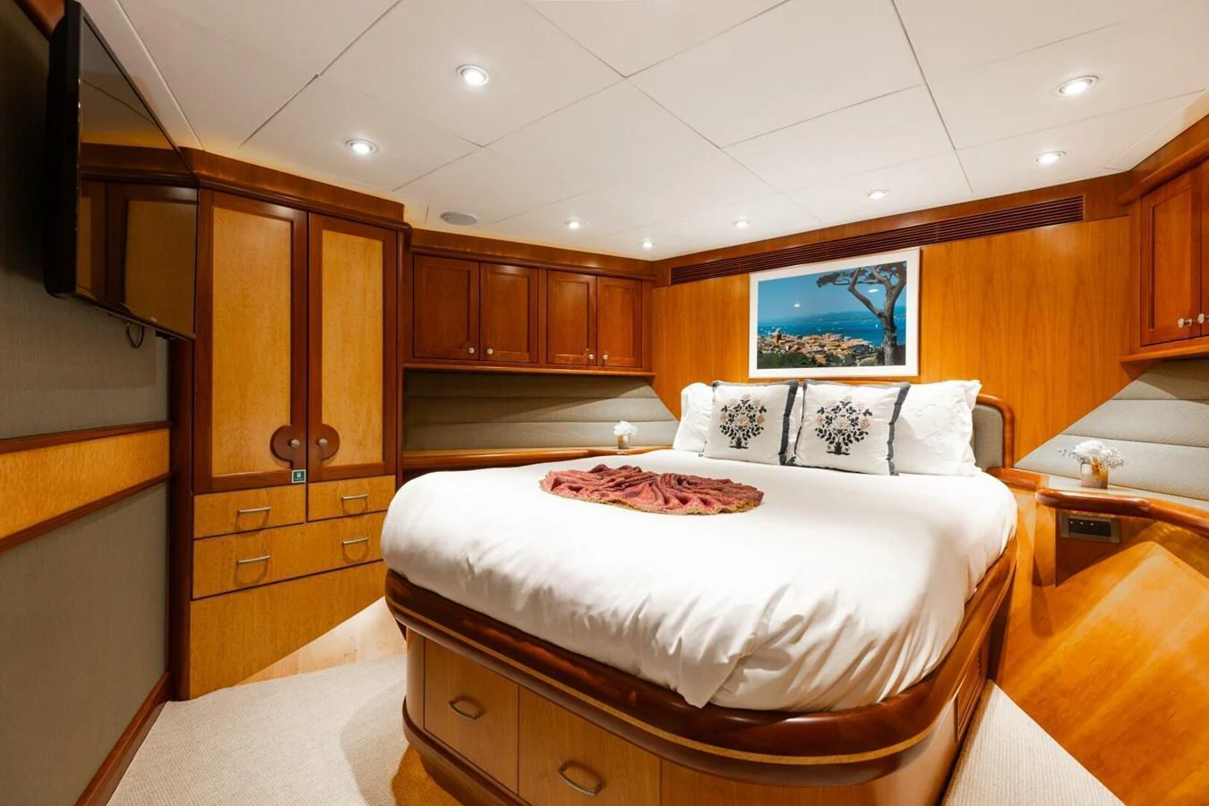 The stateroom features a plush bed with elegant wood finishes and ambient lighting. aboard AURELIA Yacht for Sale
