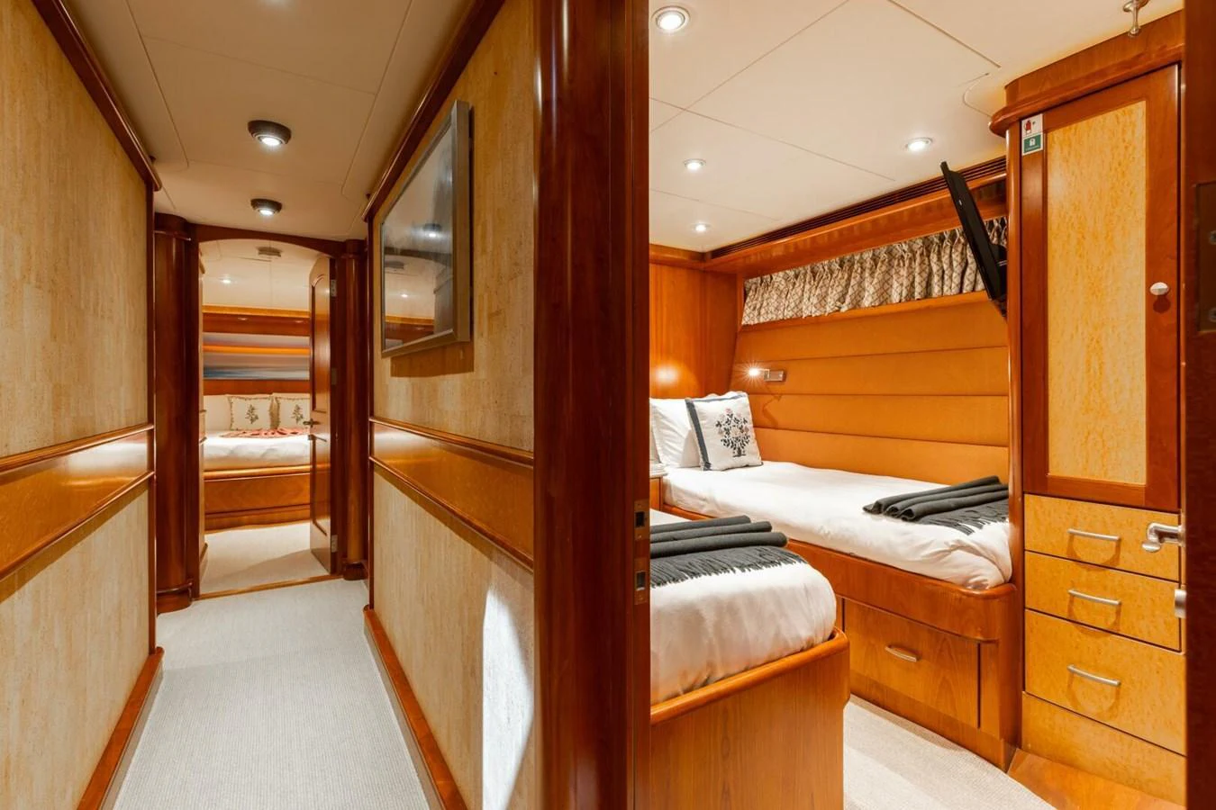 The guest stateroom features warm wood finishes and comfortable bedding, creating a cozy and inviting atmosphere. aboard AURELIA Yacht for Sale