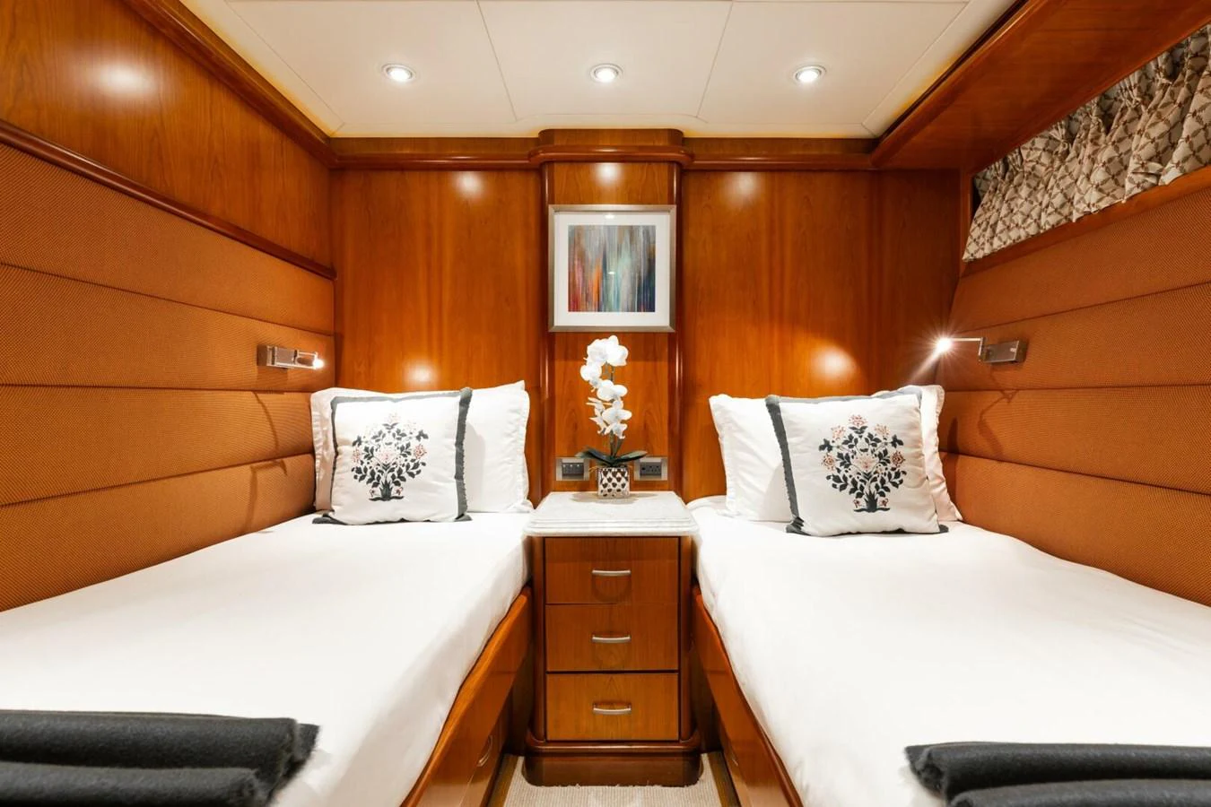 The twin stateroom features elegant wood paneling and cozy twin beds with plush bedding. aboard AURELIA Yacht for Sale