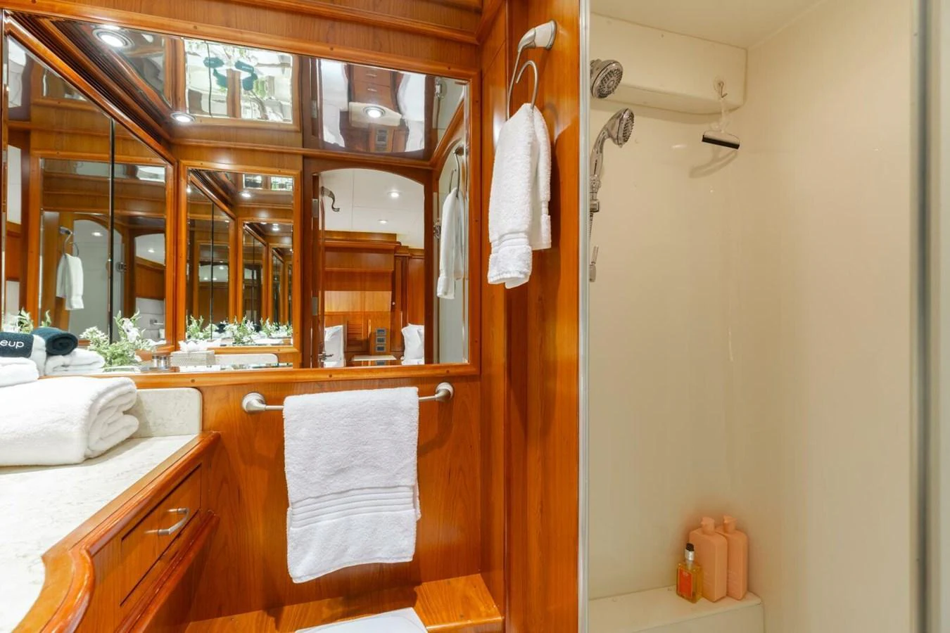 The yacht's bathroom features elegant wooden cabinetry and a well-lit vanity area. aboard AURELIA Yacht for Sale