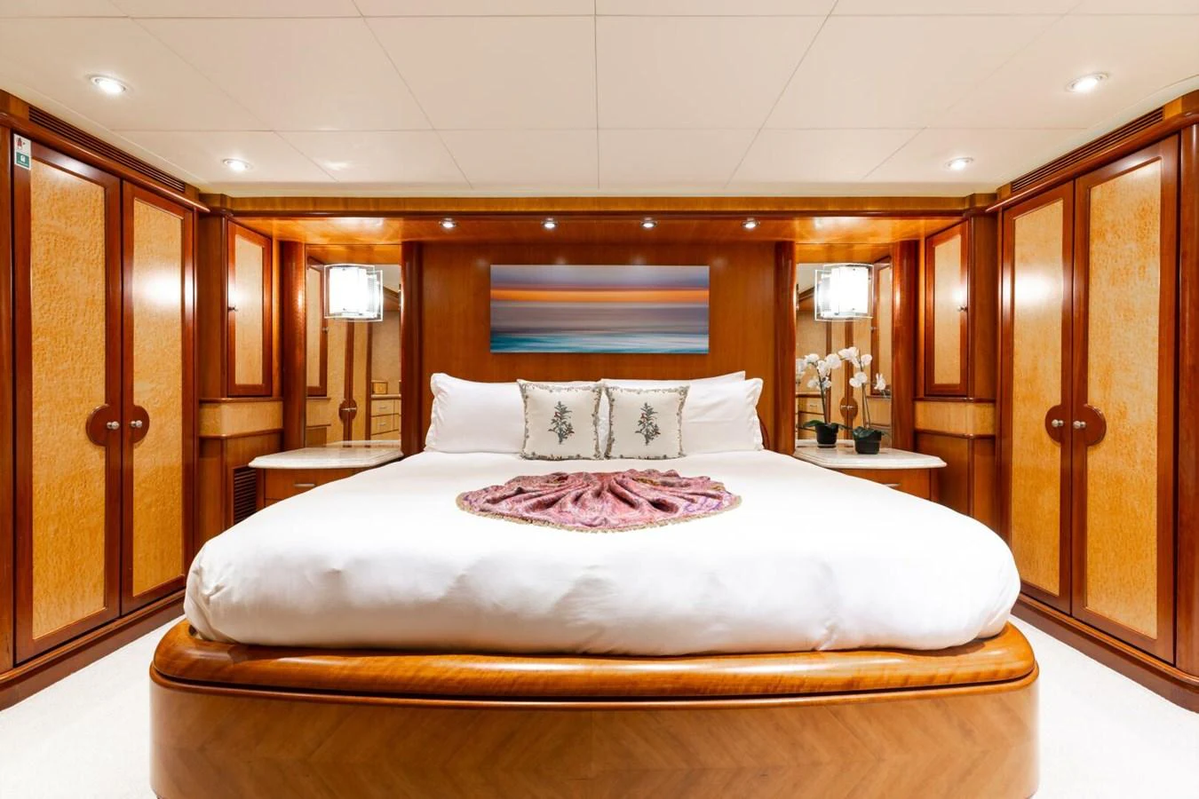 The master stateroom features a luxurious bed with elegant wood paneling and ambient lighting. aboard AURELIA Yacht for Sale