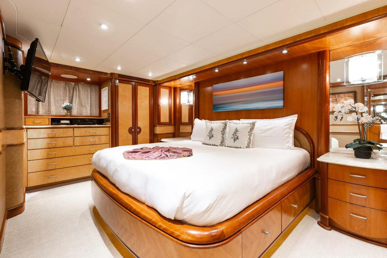 The master stateroom features a luxurious bed with elegant wood finishes and ample storage space. aboard AURELIA Yacht for Sale