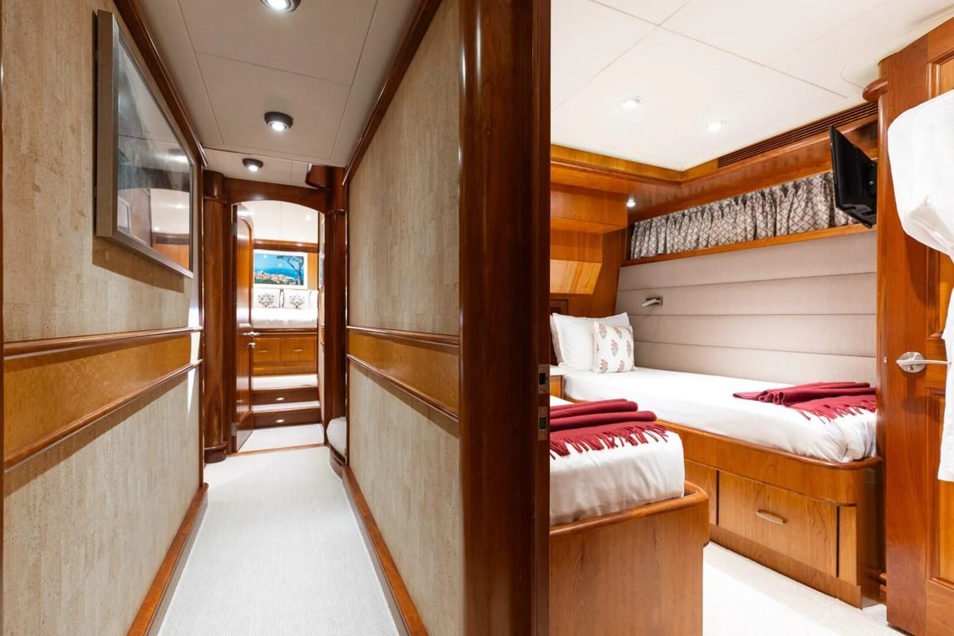 The image showcases a cozy guest cabin with warm wood finishes and a comfortable bed. aboard AURELIA Yacht for Sale