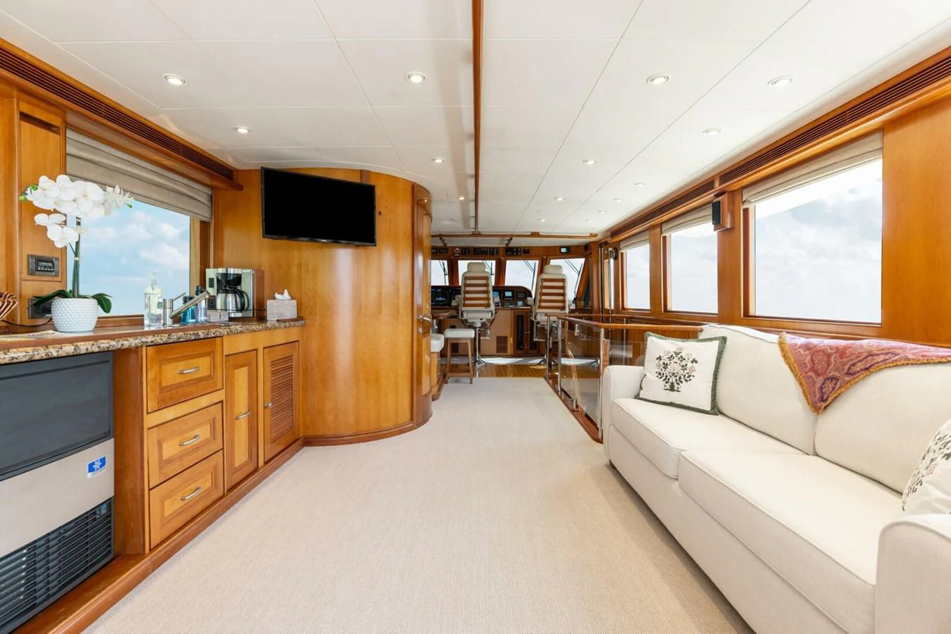 The salon features luxurious seating, a flat-screen TV, and elegant wooden cabinetry, creating a warm and inviting atmosphere. aboard AURELIA Yacht for Sale