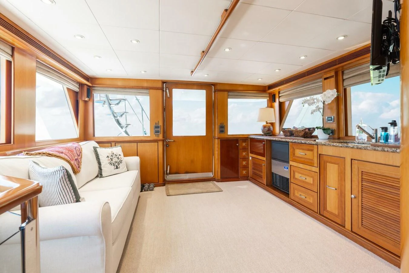 The yacht's interior features a cozy and well-lit living area with wooden cabinetry and comfortable seating. aboard AURELIA Yacht for Sale