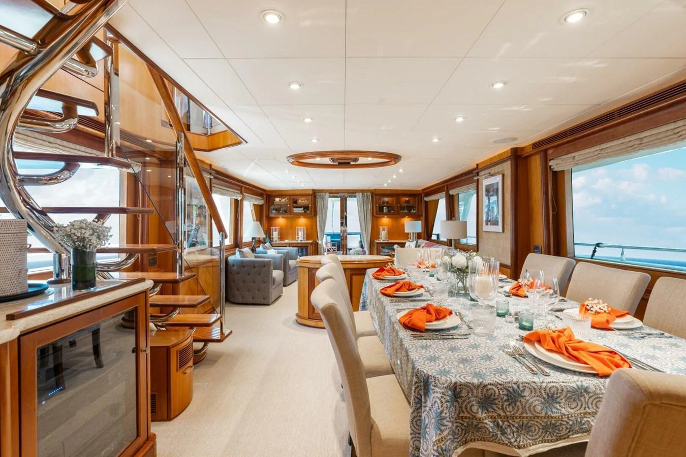 The yacht's dining area features an elegant table setting with a view of the sea through large windows. aboard AURELIA Yacht for Sale