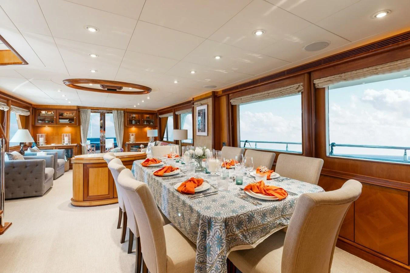 The yacht's dining area features a beautifully set table with elegant decor and ample seating, complemented by large windows offering stunning ocean views. aboard AURELIA Yacht for Sale