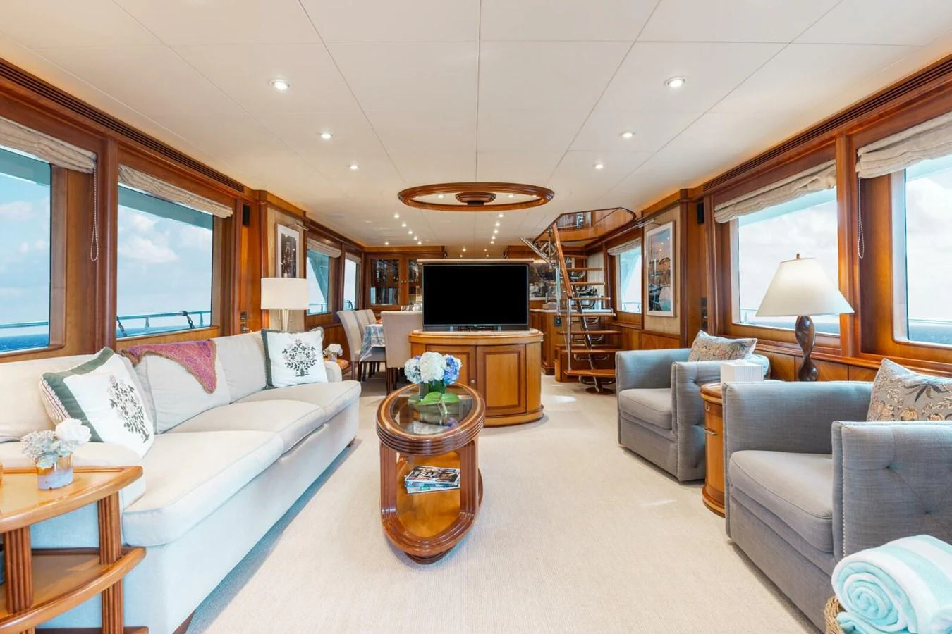 The salon features luxurious seating, elegant wood finishes, and large windows offering panoramic views. aboard AURELIA Yacht for Sale