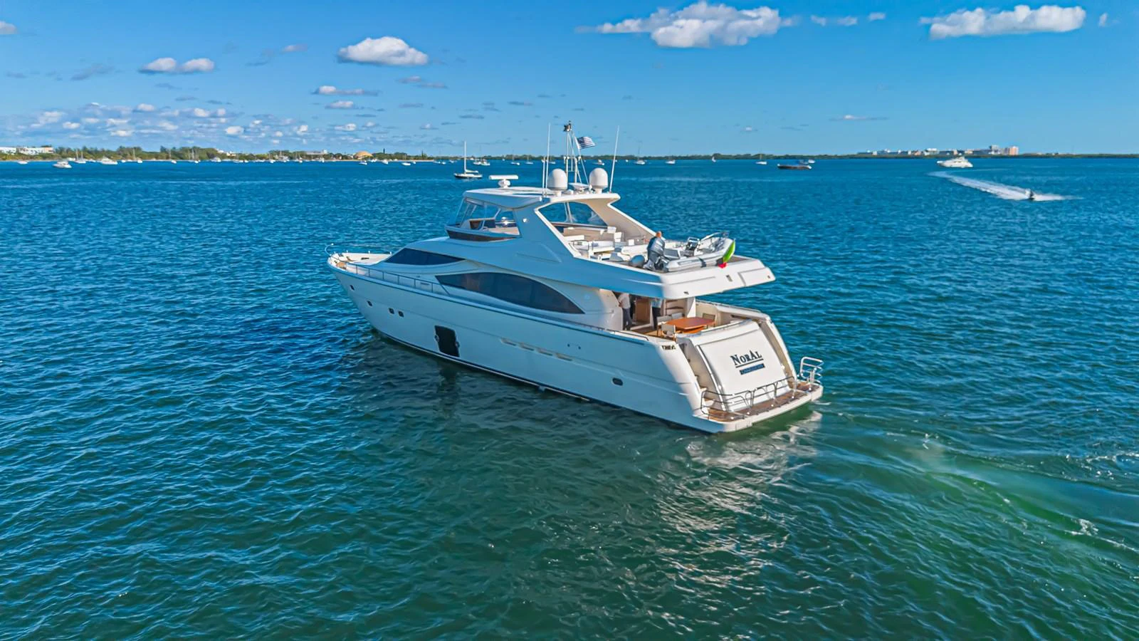 A sleek yacht cruises through calm blue waters under a clear sky. aboard NORAL Yacht for Sale