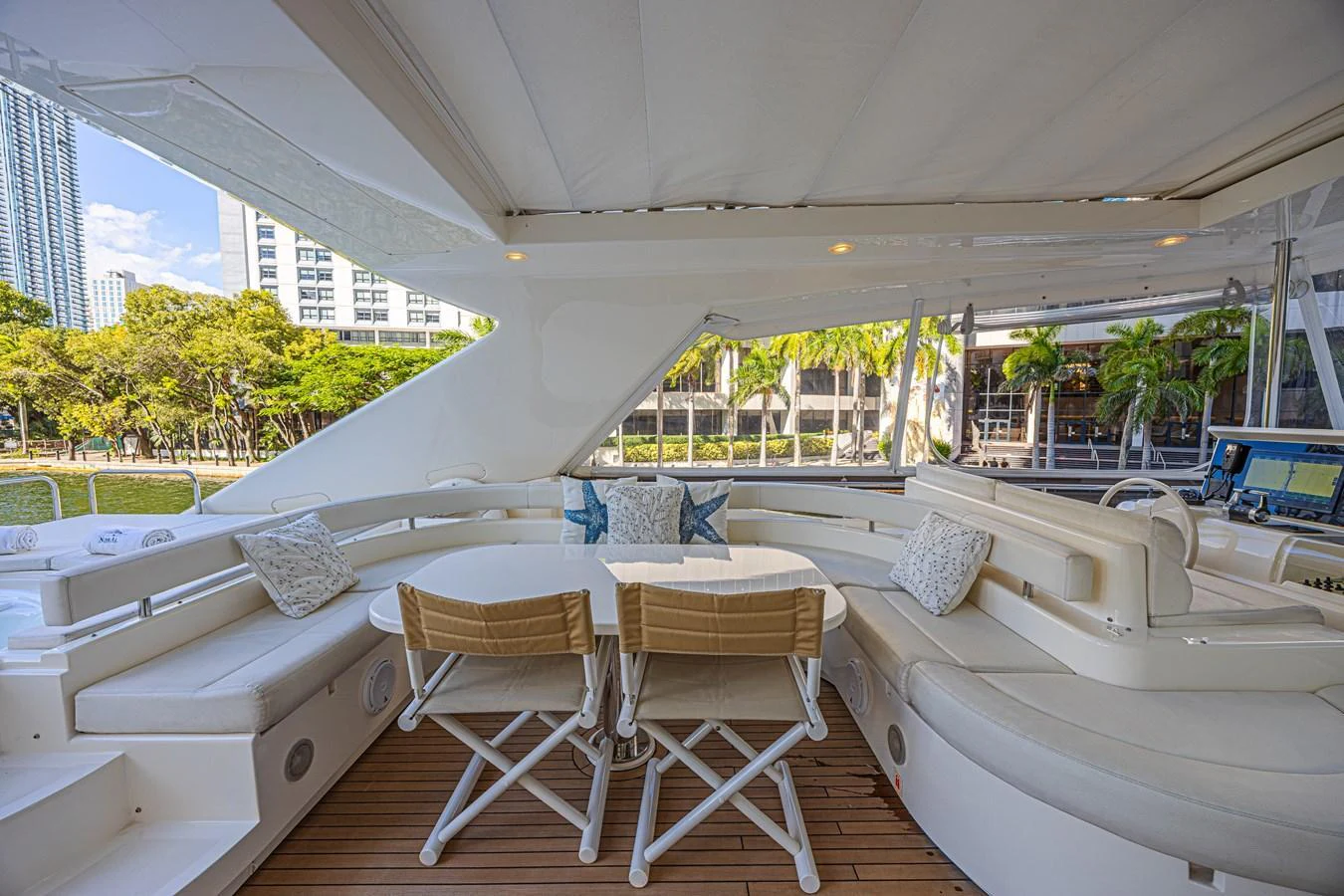 The aft deck features a spacious seating area with plush cushions and a dining table, perfect for alfresco dining. aboard NORAL Yacht for Sale