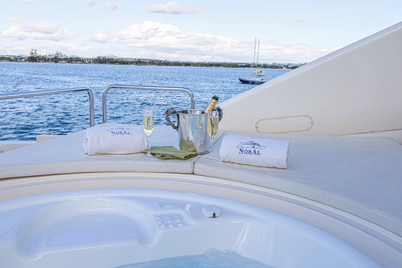 A luxurious jacuzzi on the yacht's deck, complete with champagne and towels, offers a perfect relaxation spot with a stunning sea view. aboard NORAL Yacht for Sale
