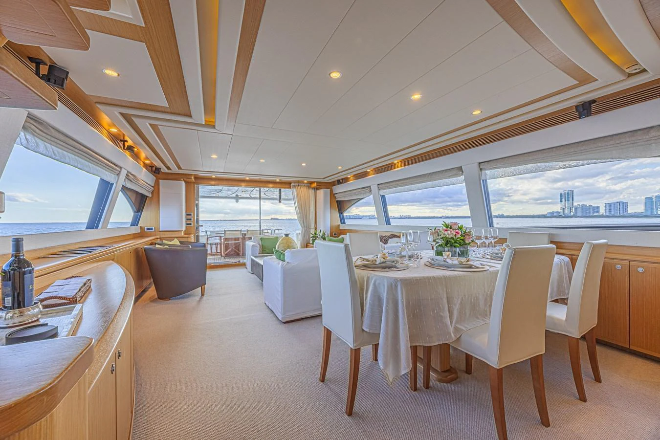 The salon offers a spacious and elegantly designed area with panoramic views and luxurious dining setup. aboard NORAL Yacht for Sale