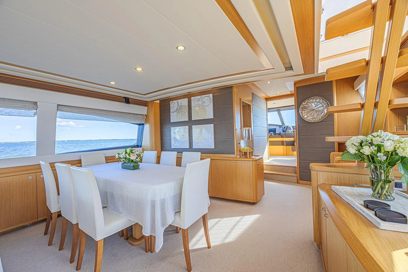 The yacht's dining area features a spacious table with elegant seating and panoramic windows offering stunning sea views. aboard NORAL Yacht for Sale