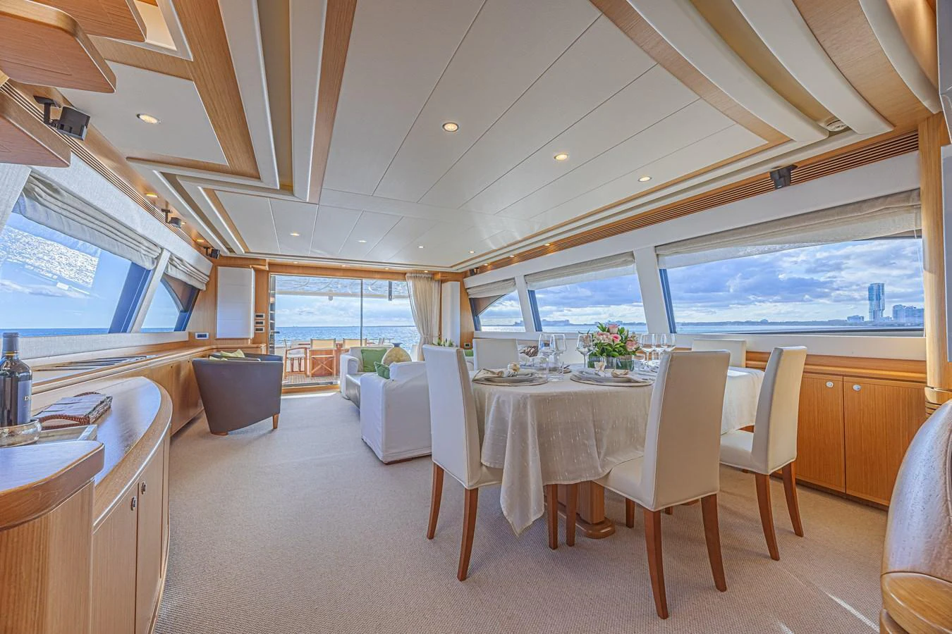 The spacious salon features elegant dining and lounging areas with panoramic views. aboard NORAL Yacht for Sale