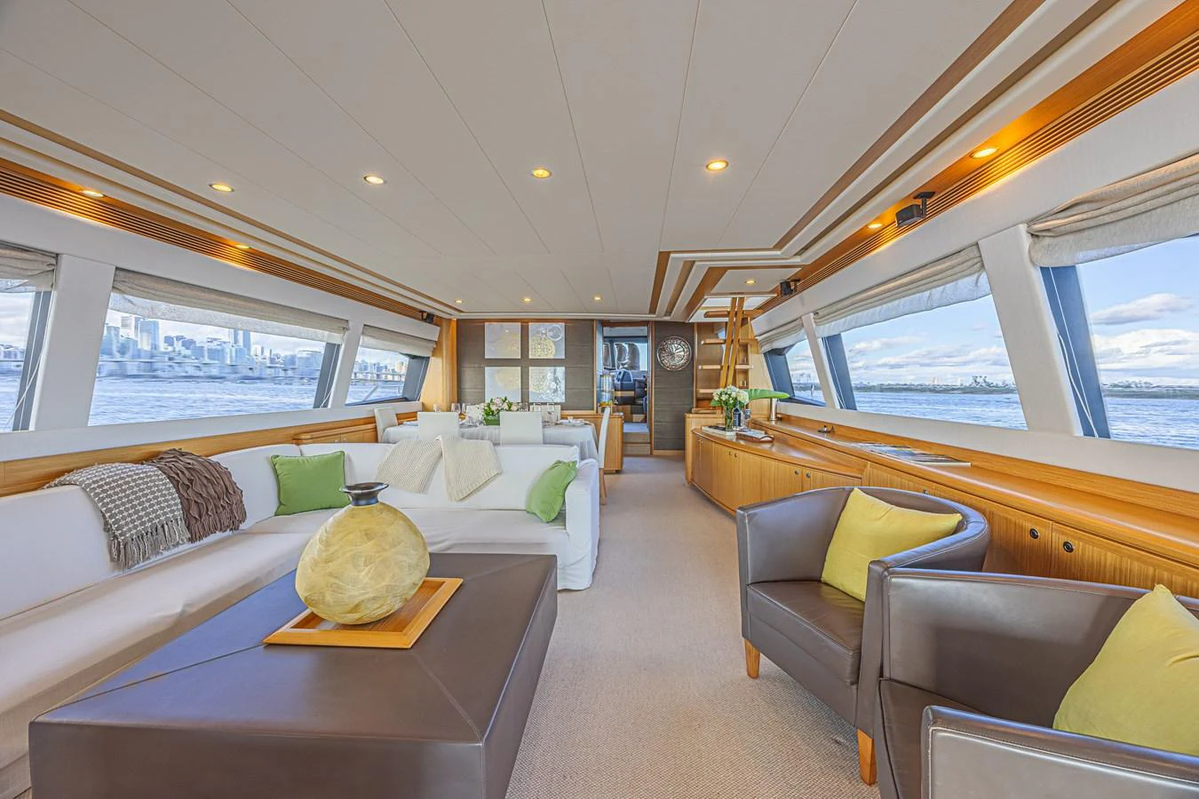 The spacious salon features comfortable seating with panoramic views through large windows. aboard NORAL Yacht for Sale