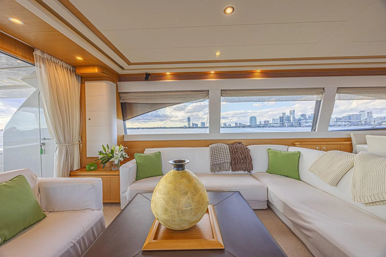 The salon offers a spacious and elegant seating area with panoramic views of the city skyline. aboard NORAL Yacht for Sale