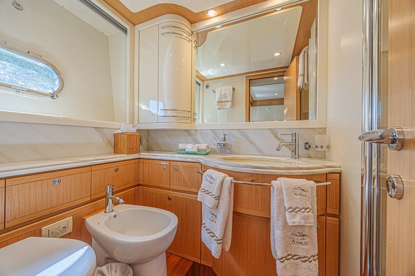 The yacht's bathroom features elegant wood cabinetry and modern fixtures. aboard NORAL Yacht for Sale