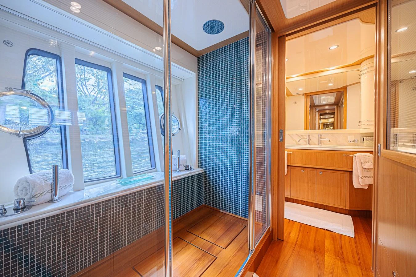 The yacht's bathroom features elegant wood finishes, a spacious shower, and large windows for natural light. aboard NORAL Yacht for Sale