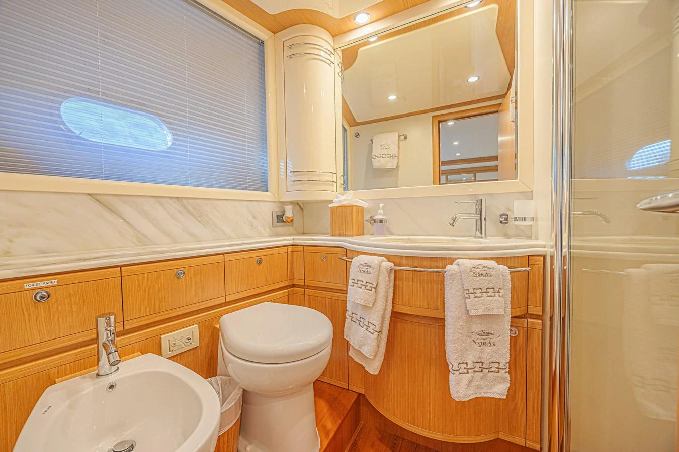 The yacht's bathroom features elegant wood cabinetry and modern fixtures, creating a luxurious and comfortable space. aboard NORAL Yacht for Sale