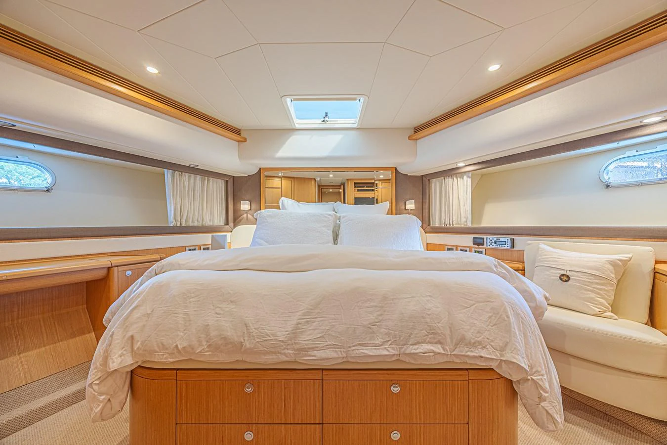 The master stateroom features a luxurious bed with ample natural light from side windows and a skylight. aboard NORAL Yacht for Sale