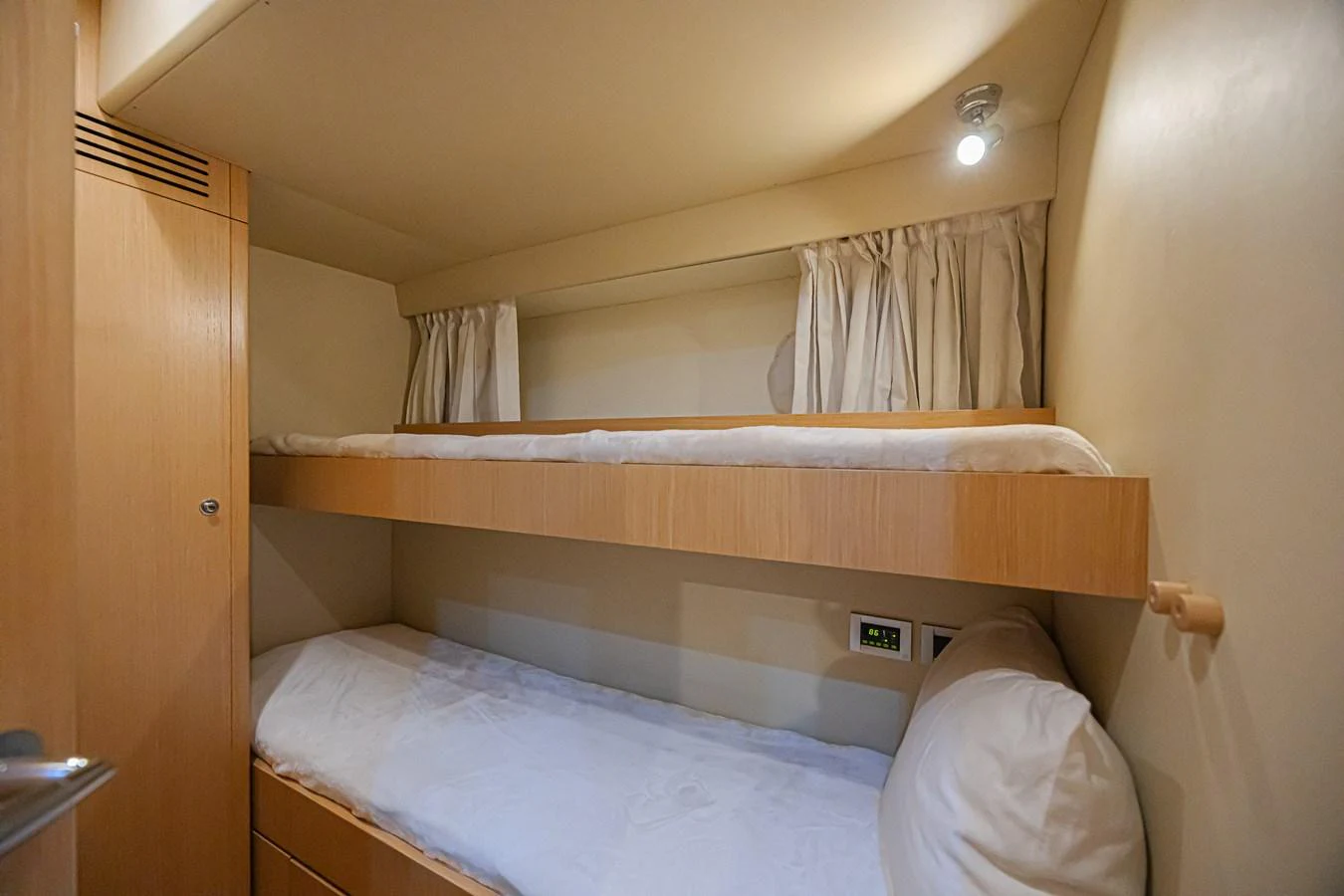 The cozy bunk cabin features two neatly arranged beds with soft lighting and simple decor. aboard NORAL Yacht for Sale