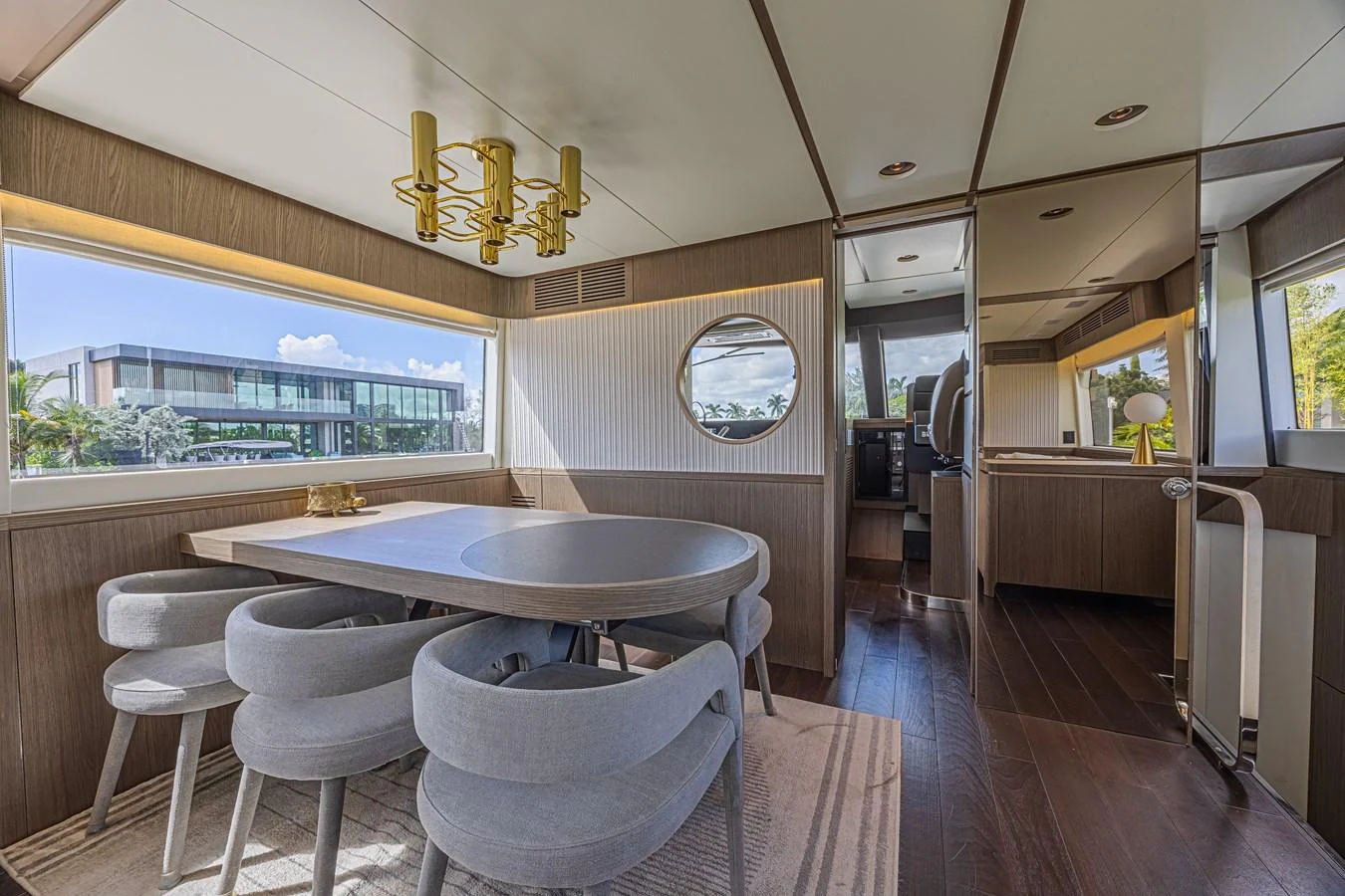 The yacht's dining area features a modern table with stylish chairs and large windows offering scenic views. aboard XAX66M61L122 Yacht for Sale