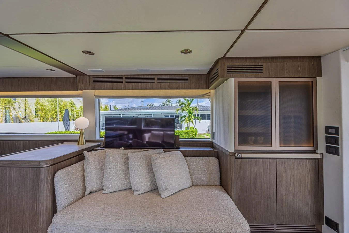 The yacht's salon features a cozy seating area with a television and large windows offering scenic views. aboard XAX66M61L122 Yacht for Sale