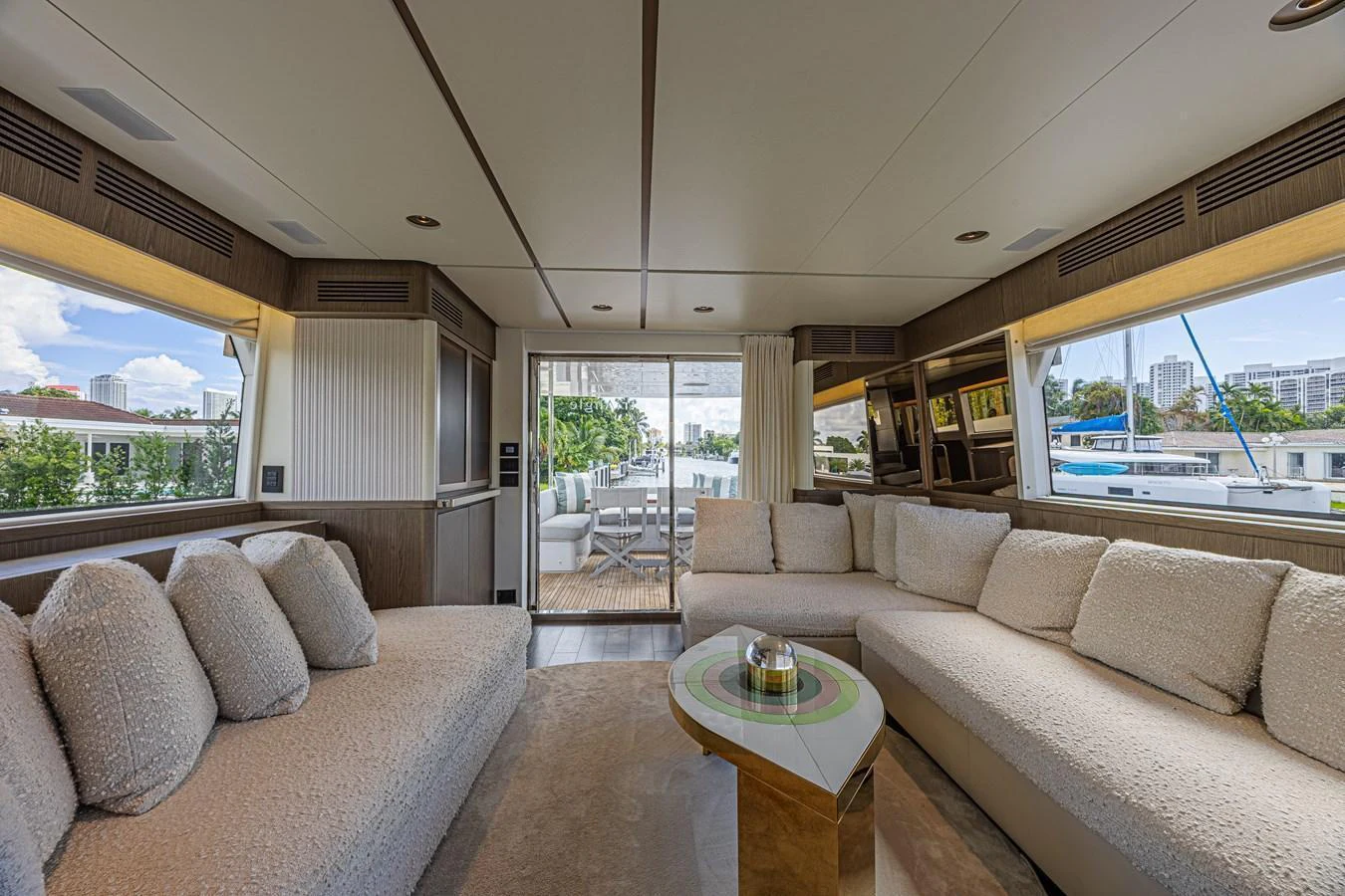 The salon features plush seating and a modern design with ample natural light. aboard XAX66M61L122 Yacht for Sale