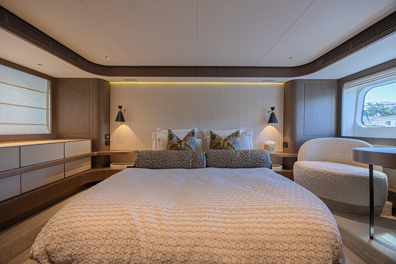 The master stateroom features a luxurious bed with elegant lighting and ample natural light from the window. aboard XAX66M61L122 Yacht for Sale