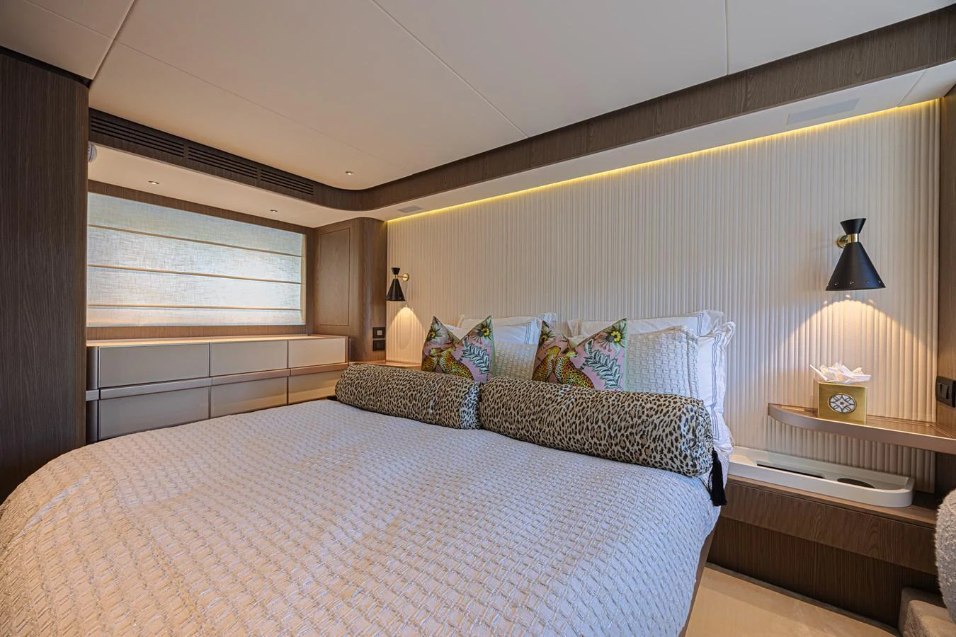 The stateroom features a luxurious bed with elegant bedding and modern lighting. aboard XAX66M61L122 Yacht for Sale