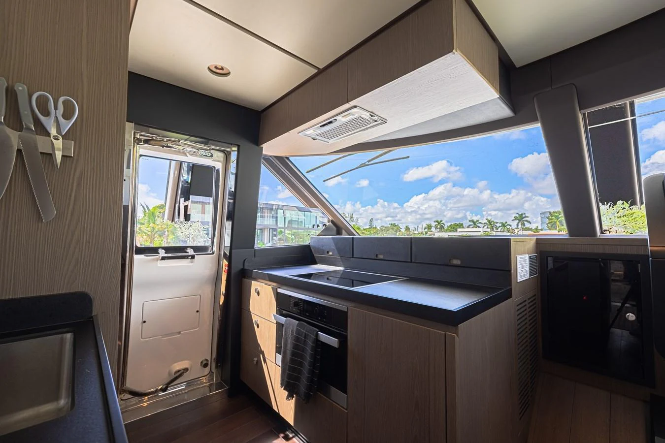 A modern galley with sleek cabinetry and large windows offering a scenic view. aboard XAX66M61L122 Yacht for Sale