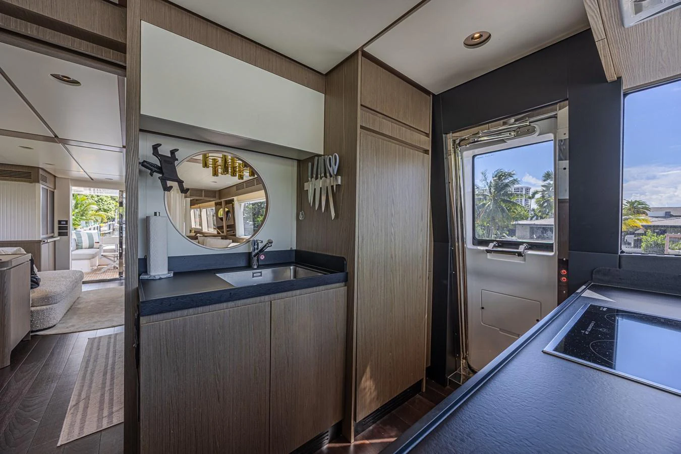 The yacht's galley features modern cabinetry and a sleek design with a view of the exterior through a door. aboard XAX66M61L122 Yacht for Sale