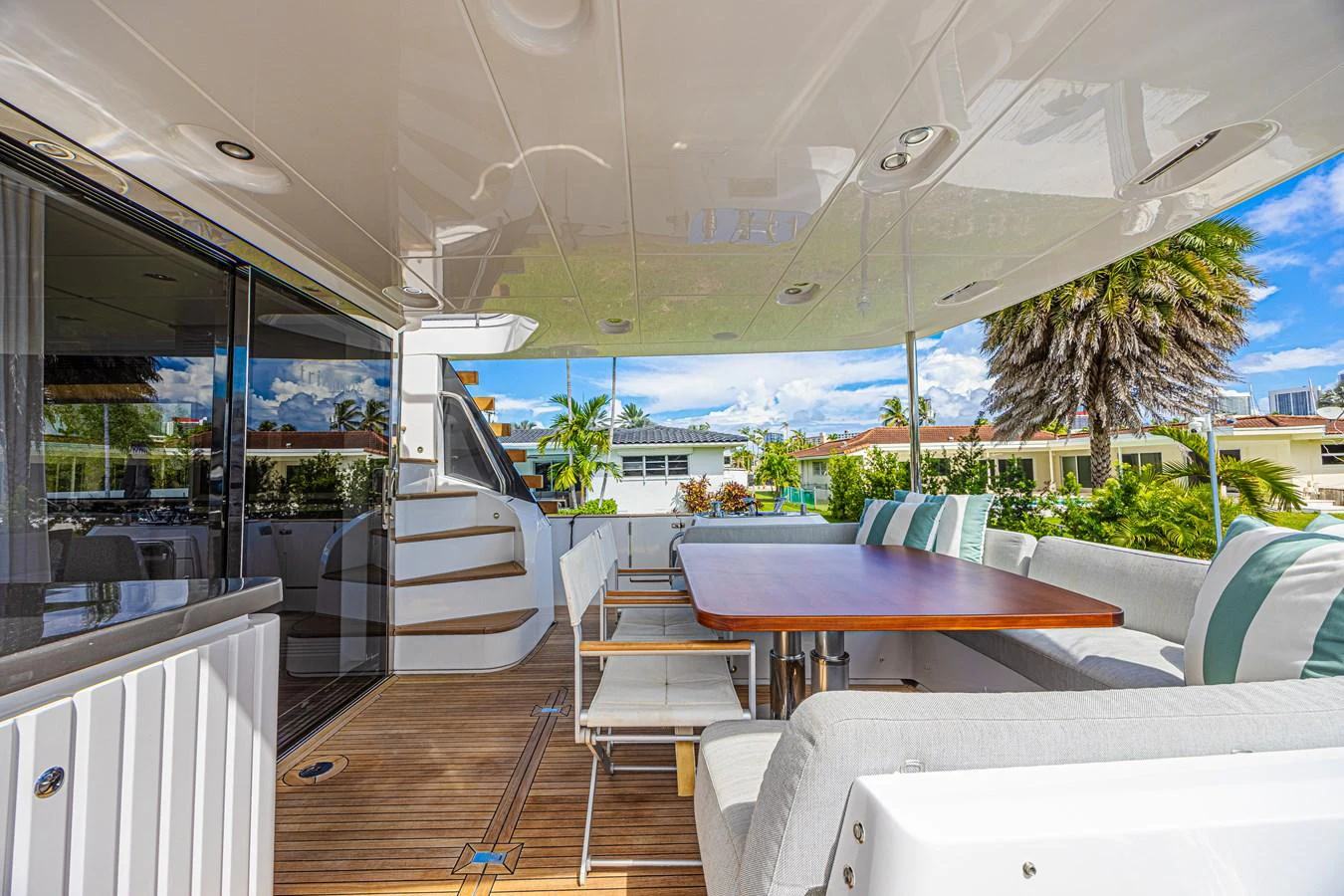 The aft deck features a spacious seating area with a dining table, perfect for outdoor meals and relaxation. aboard XAX66M61L122 Yacht for Sale