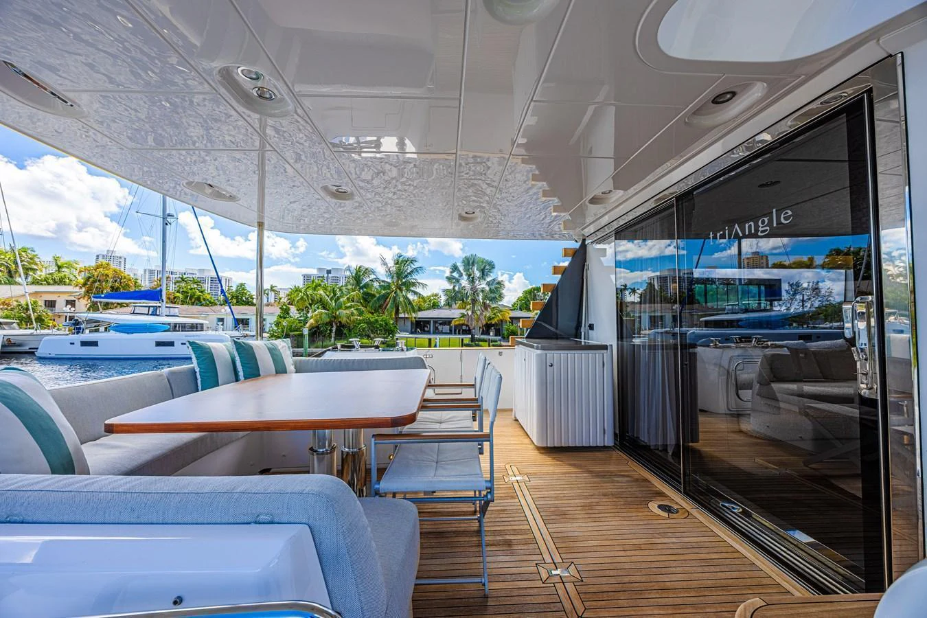 The aft deck features a spacious dining area with comfortable seating and a view of the marina. aboard XAX66M61L122 Yacht for Sale