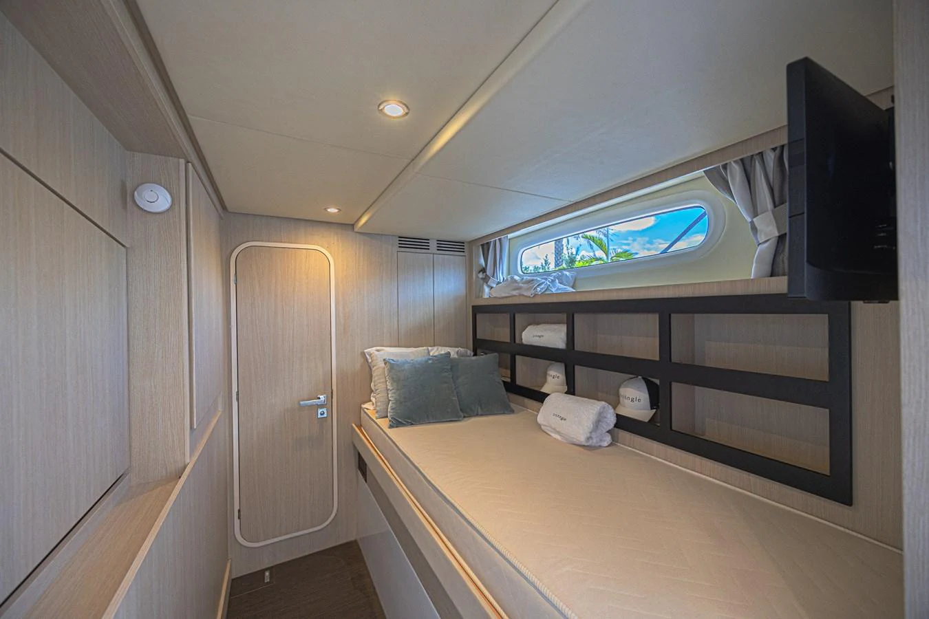 The guest cabin features a cozy bed with modern amenities and a window offering natural light. aboard XAX66M61L122 Yacht for Sale