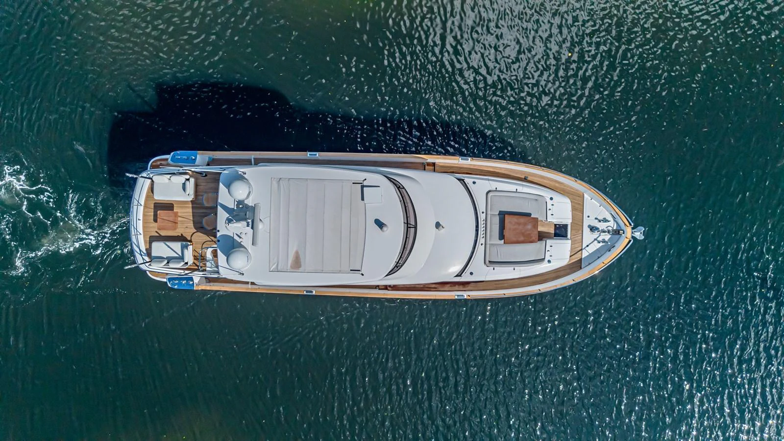 A sleek yacht glides gracefully through the water, showcasing its elegant design from an aerial perspective. aboard XAX66M61L122 Yacht for Sale
