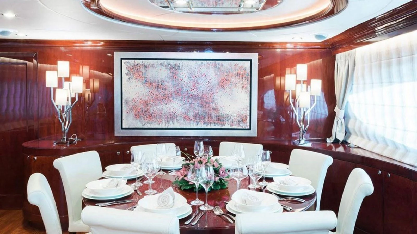 a dining room table with a large painting on the wall aboard ALBATOR 2 Yacht for Sale