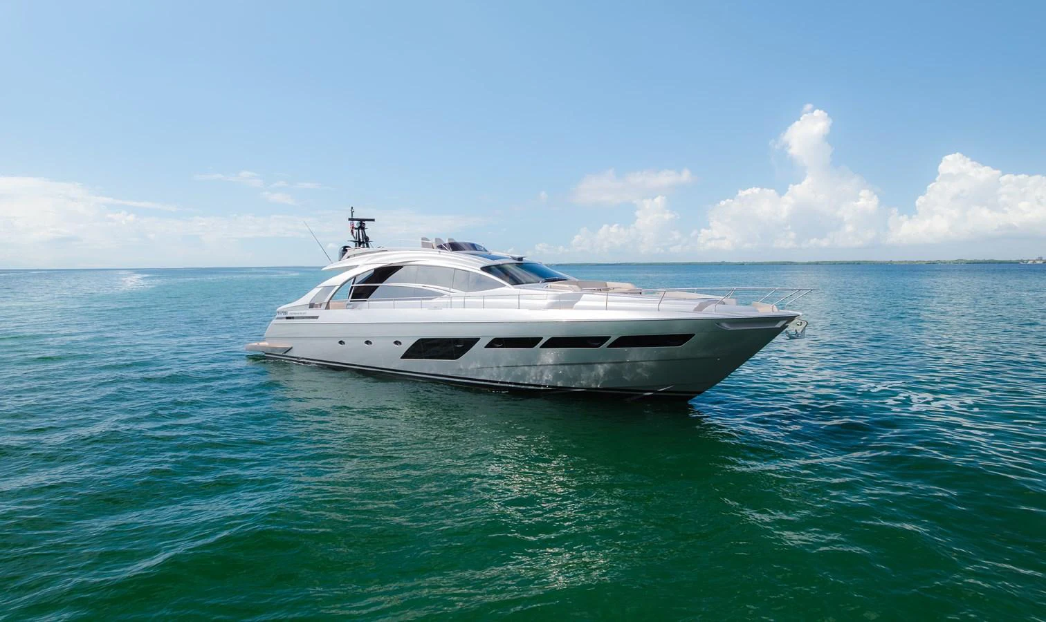 A sleek and modern yacht glides gracefully on the open sea under a clear blue sky. aboard NOVA Yacht for Sale