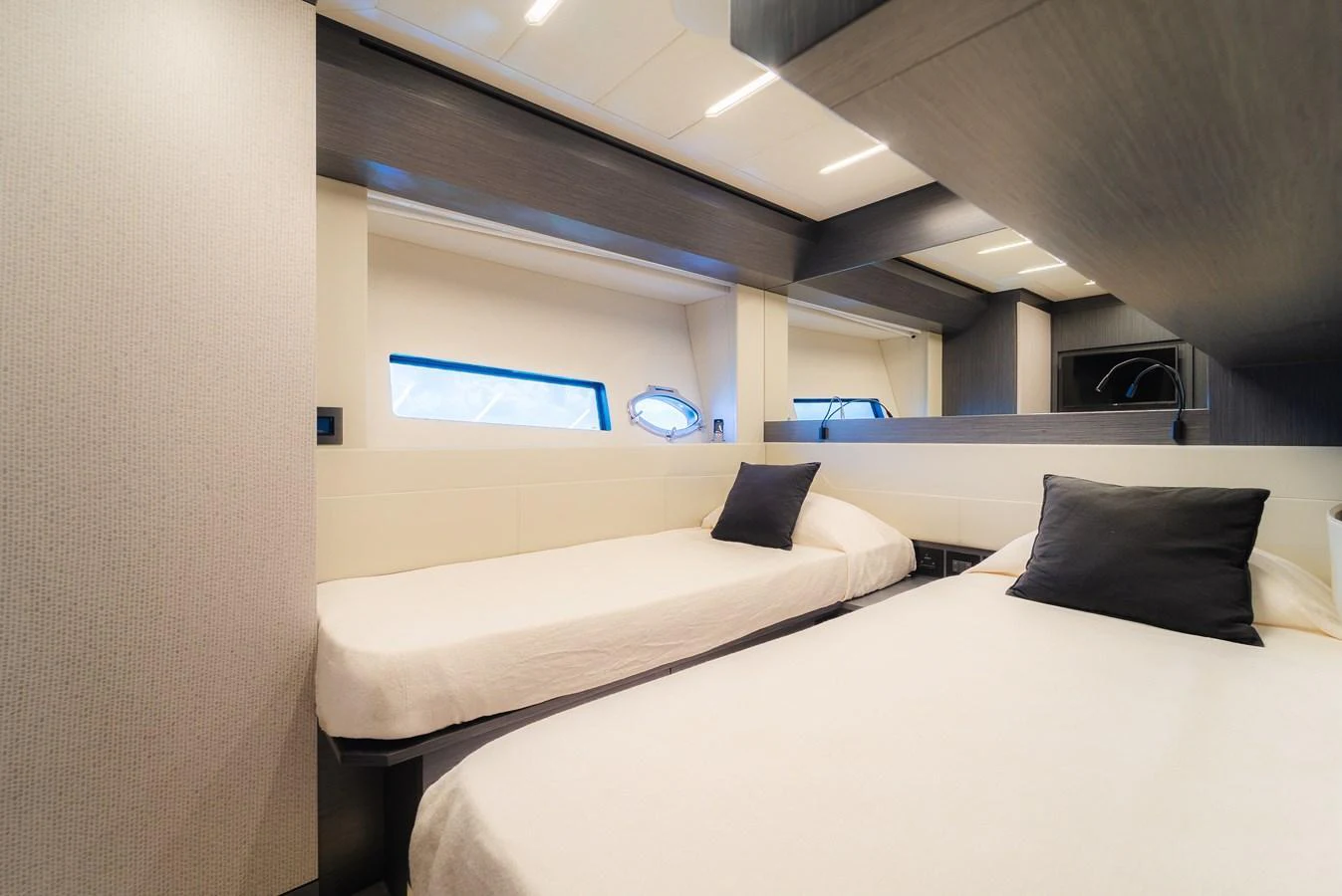The guest stateroom features twin beds and modern decor. aboard NOVA Yacht for Sale