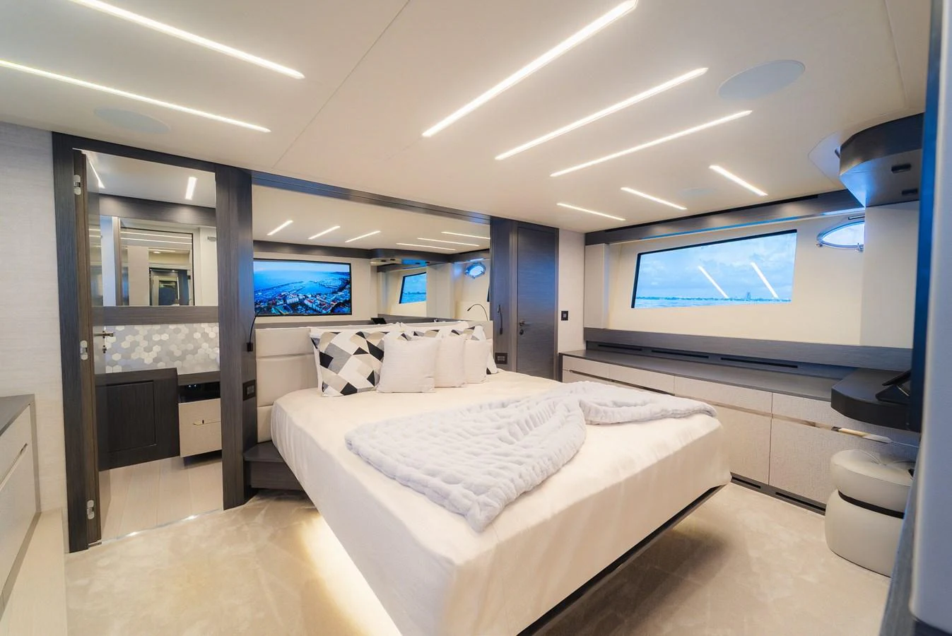 The master stateroom features a spacious bed, modern lighting, and large windows offering stunning views. aboard NOVA Yacht for Sale